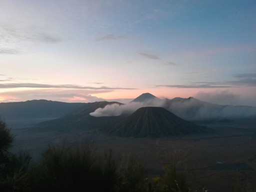 Il Vulcano Bromo sale dalle nebbie del mattino e definisce paesaggio di Java Est